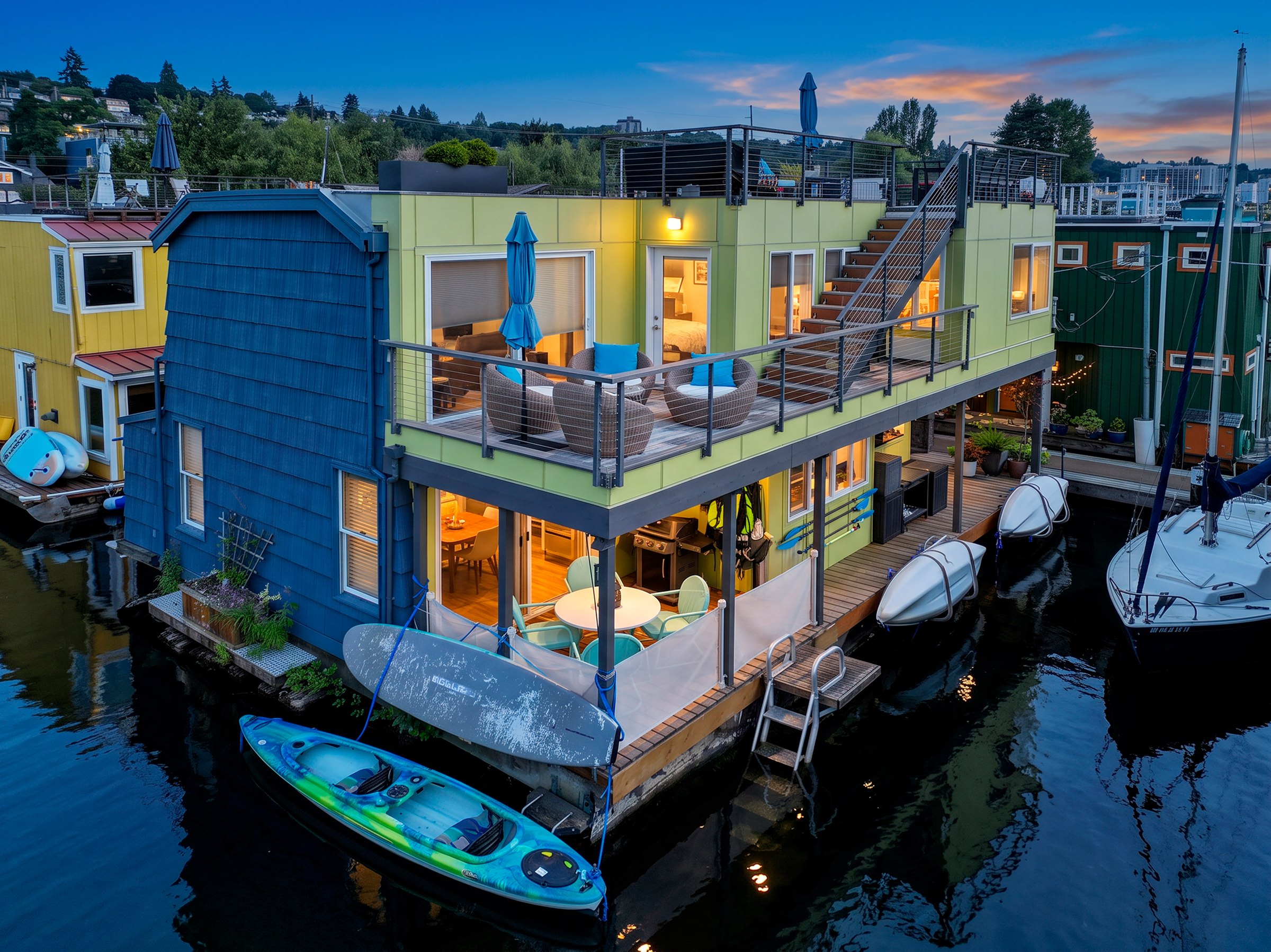 Aerial twilight view of a remodeled Eastlake floating home with illuminated decks