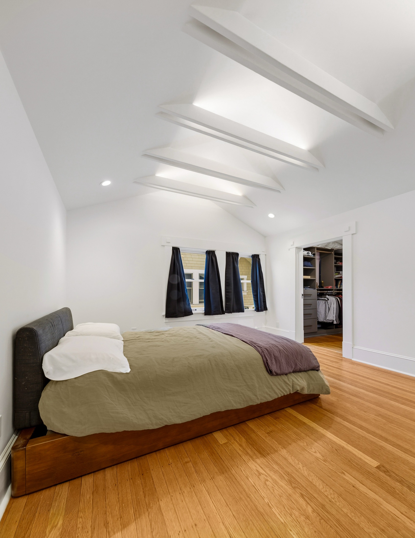 Primary bedroom with vaulted ceiling and adjoining closet