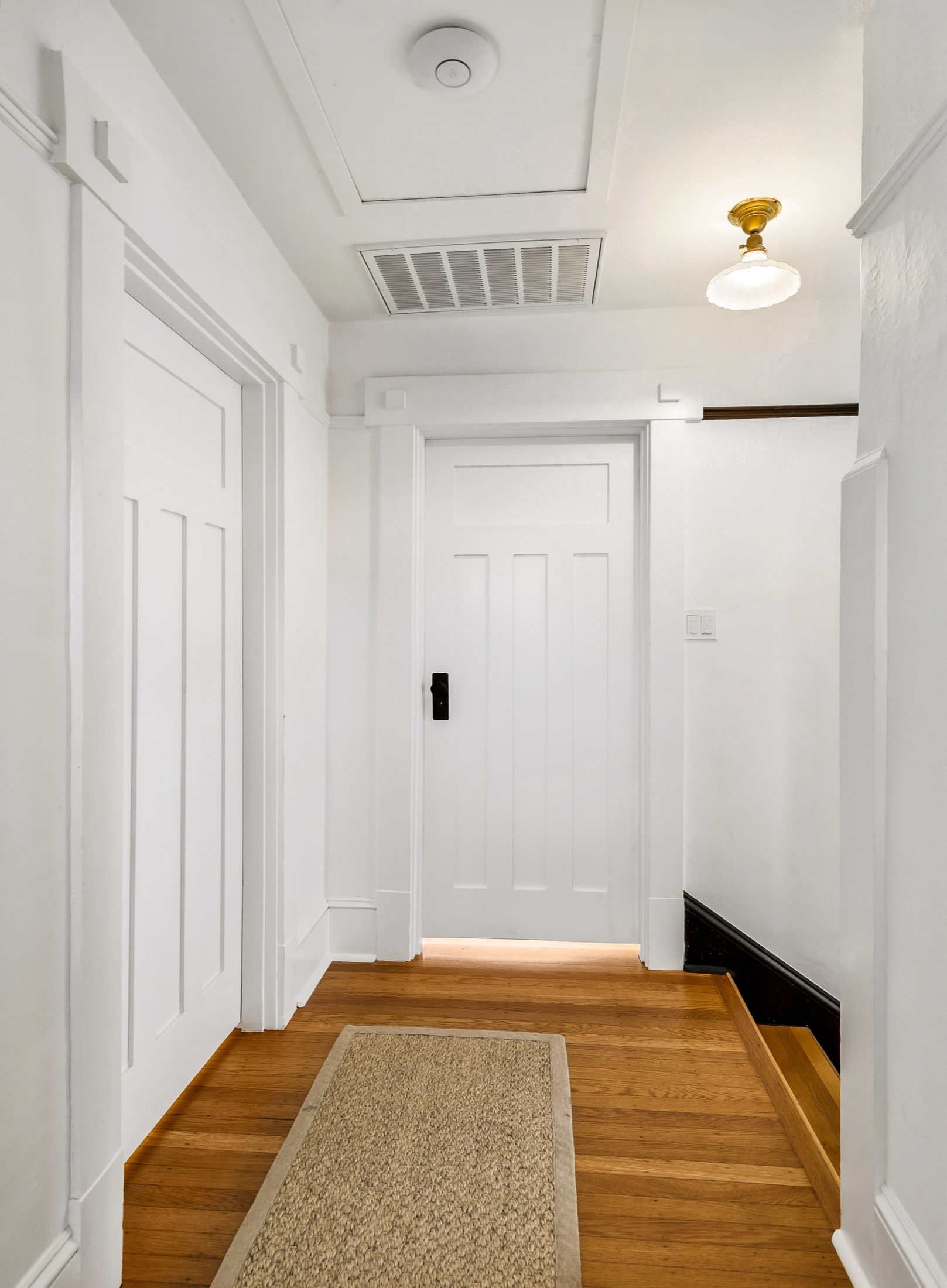 Hallway with custom trim leading into the primary suite