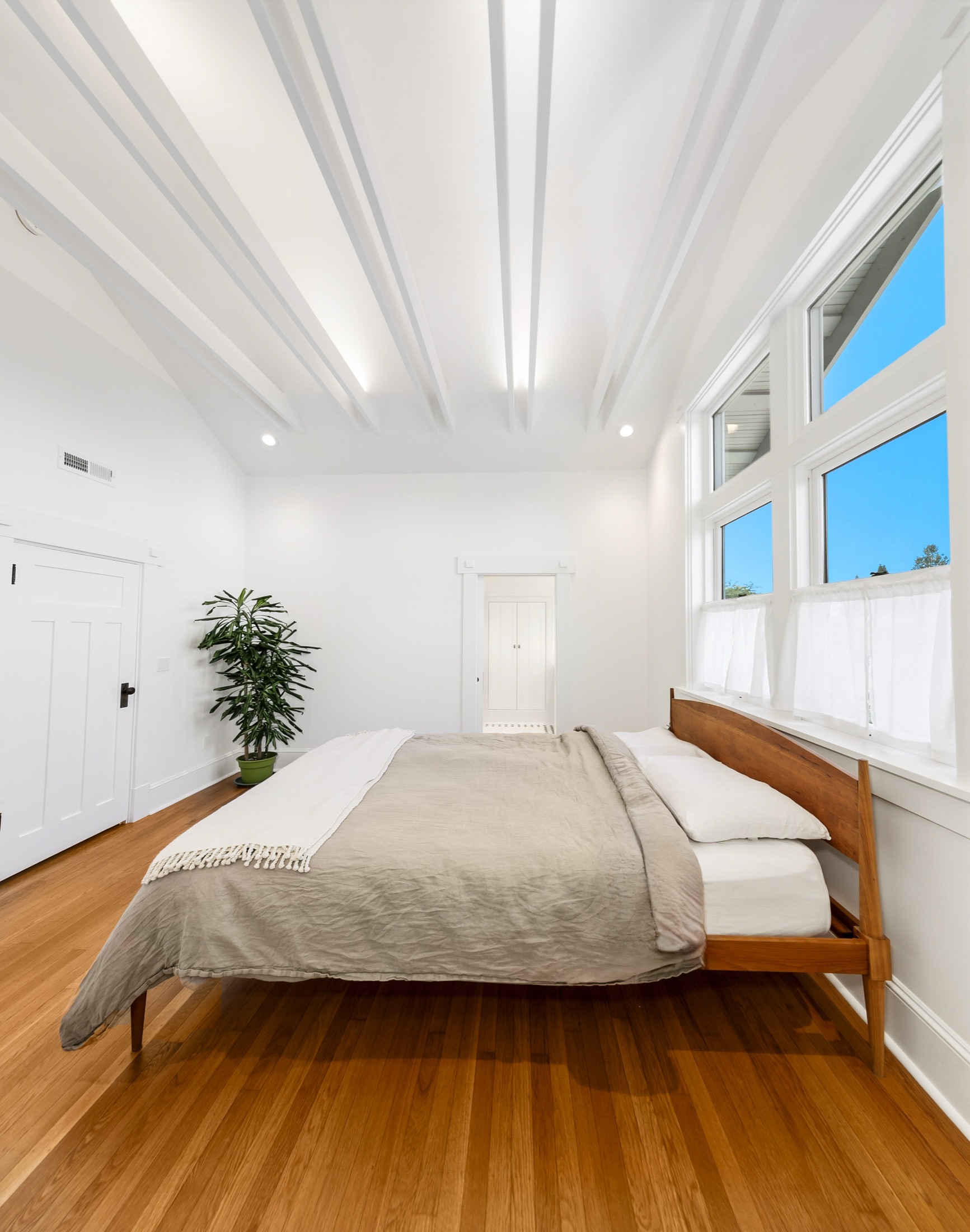 Primary bedroom with high windows and illuminated ceiling details
