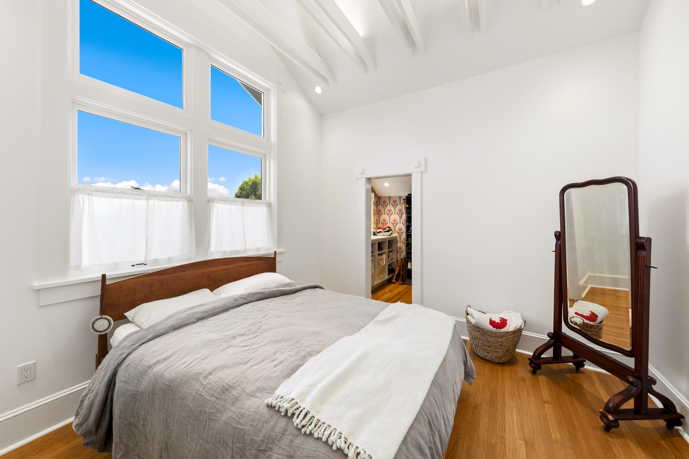 Primary bedroom with tall windows and adjoining dressing area