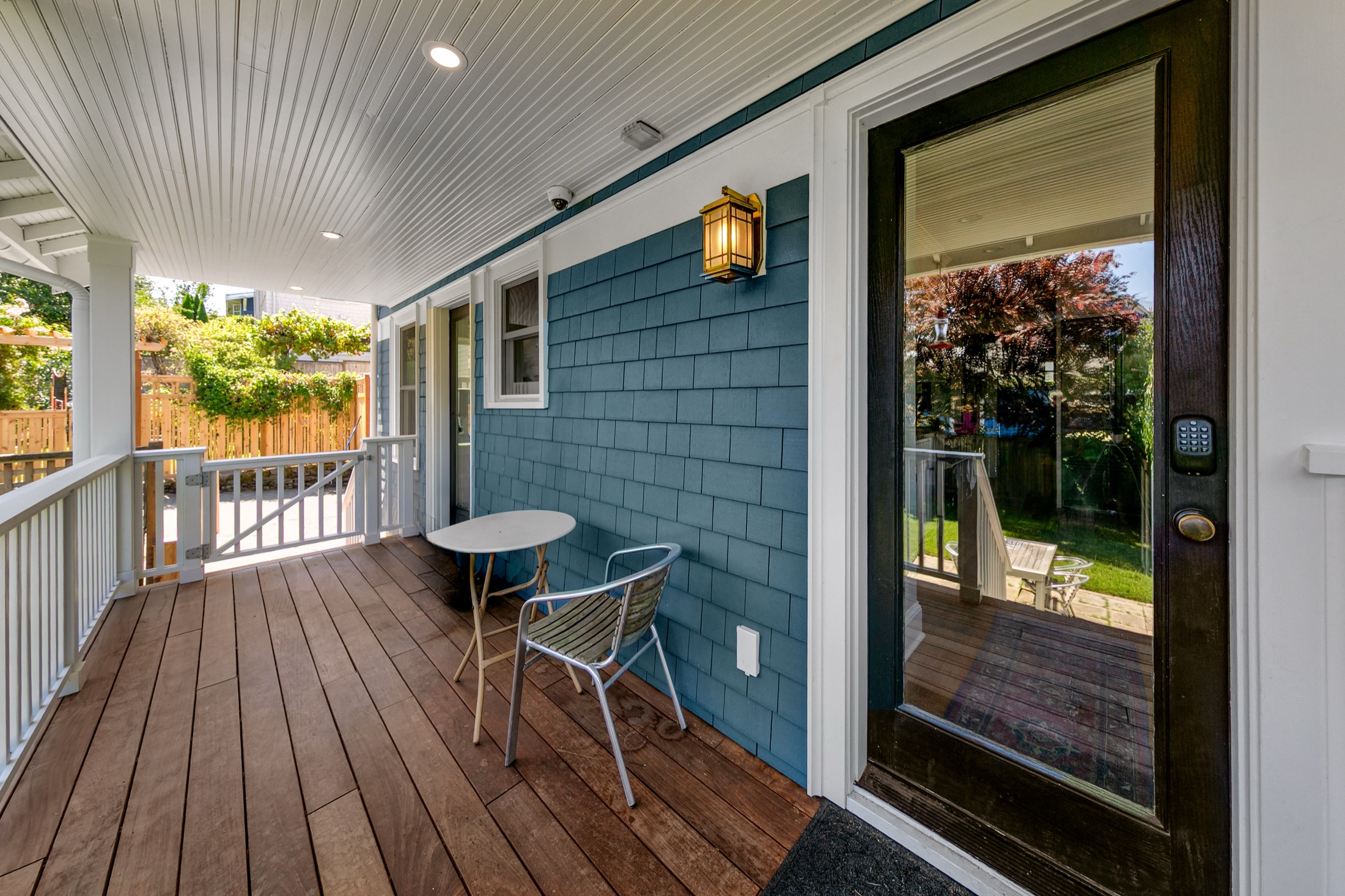 Covered heated porch with beadboard ceiling and garden view