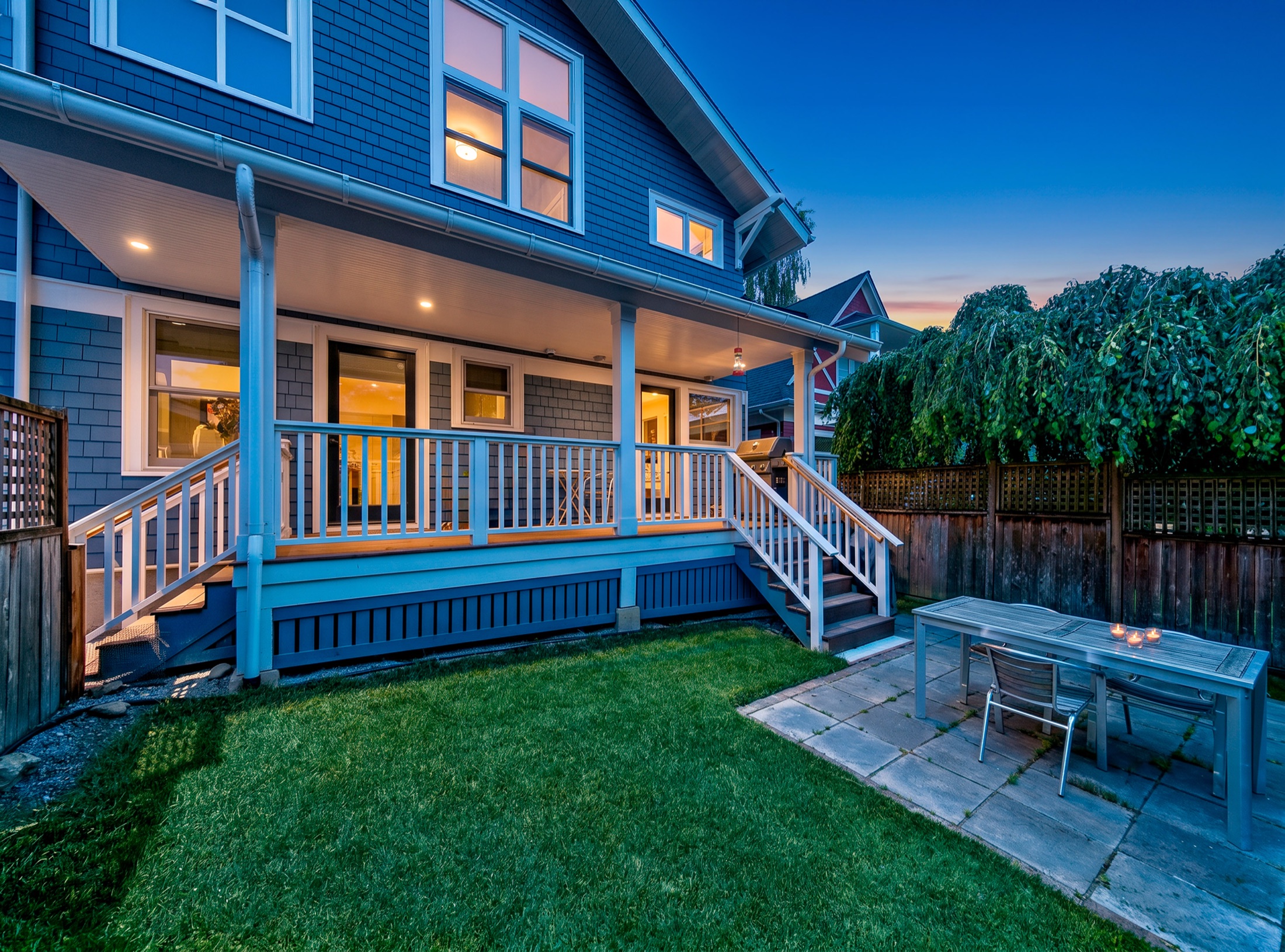 Rear exterior and illuminated covered porch at twilight
