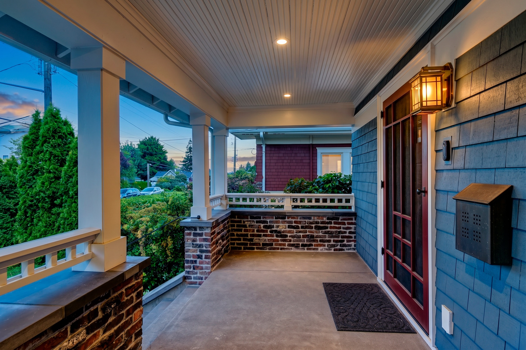 Covered front porch illuminated at twilight