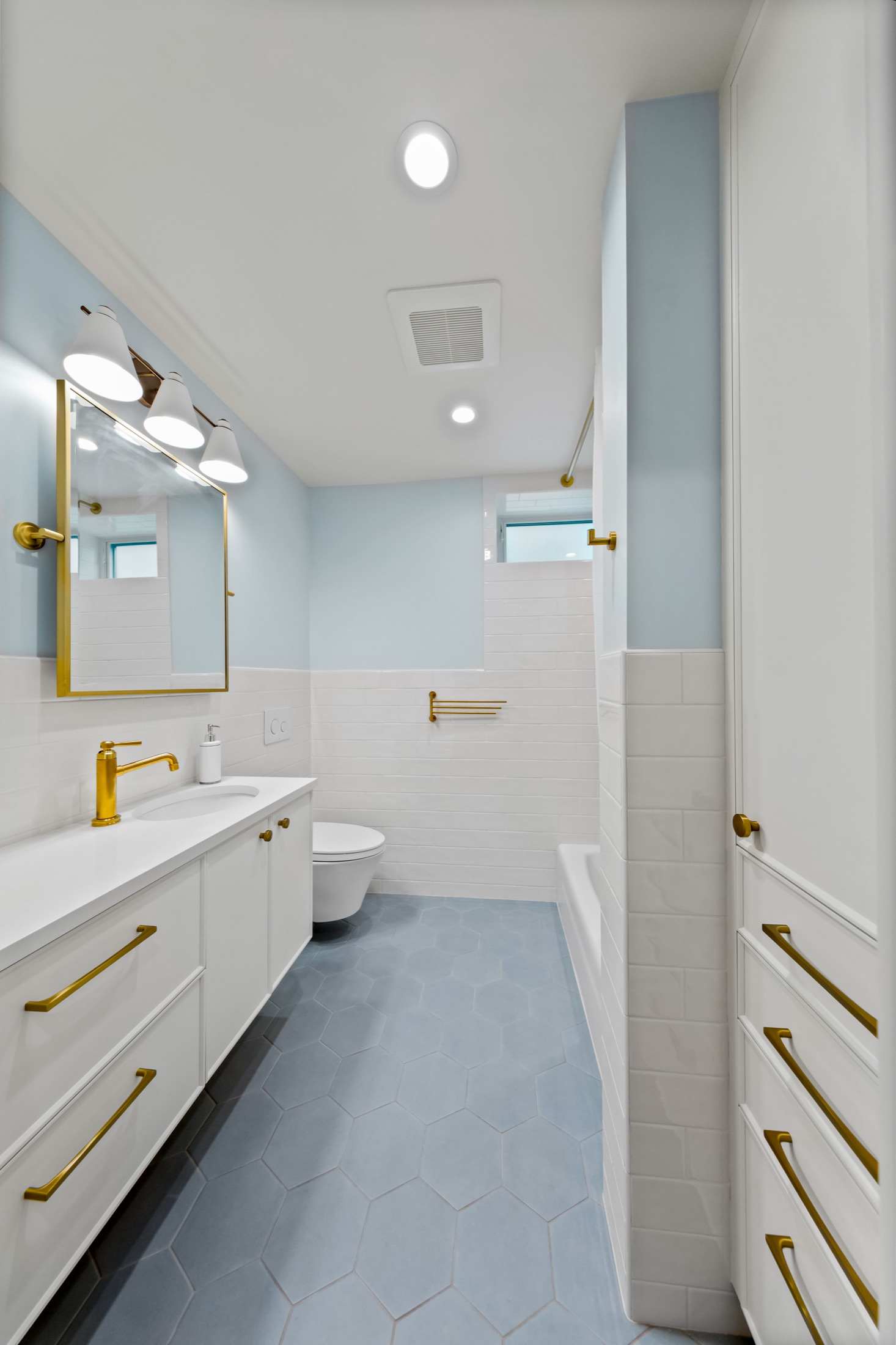 Full view of the light blue bathroom and vanity