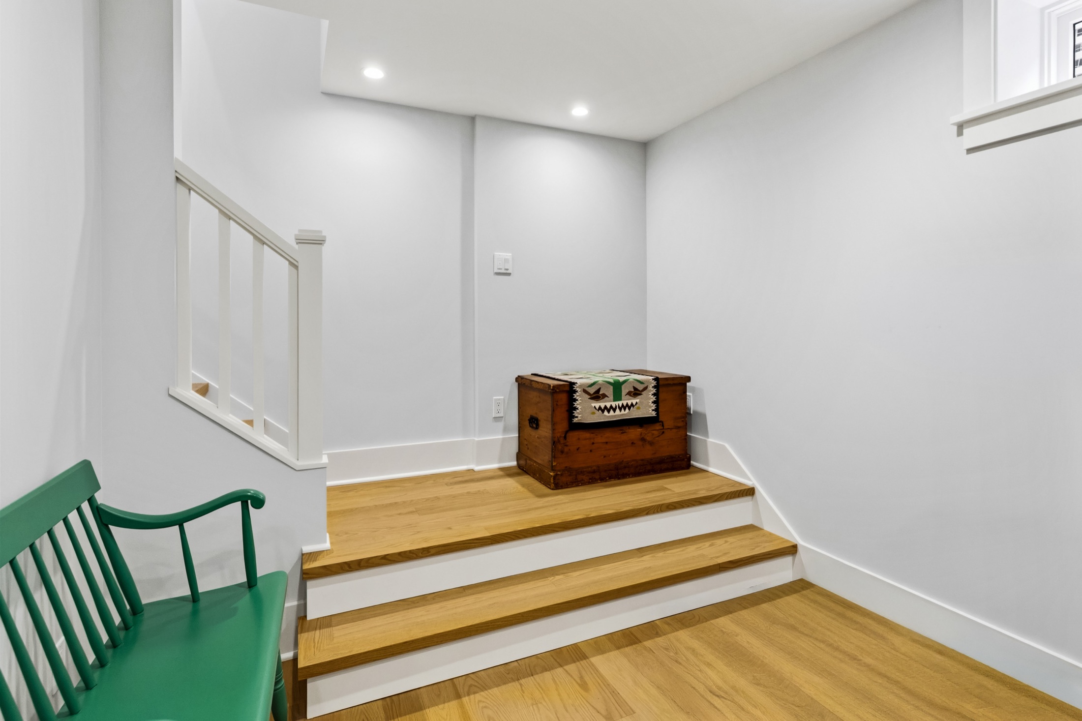 Tangletown stair landing with white railing and hardwood floors