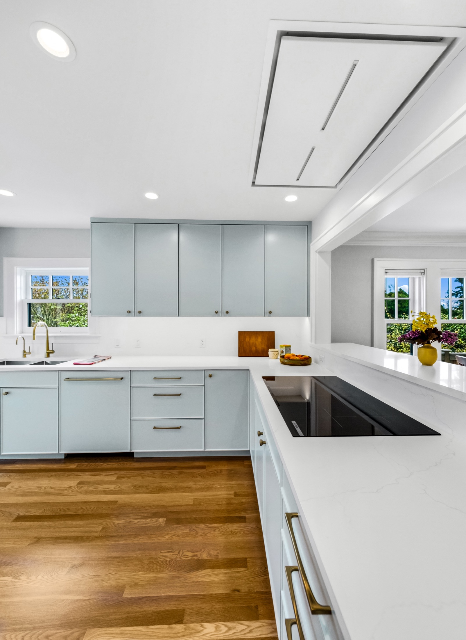 Kitchen island and cabinetry beneath a flush ceiling hood