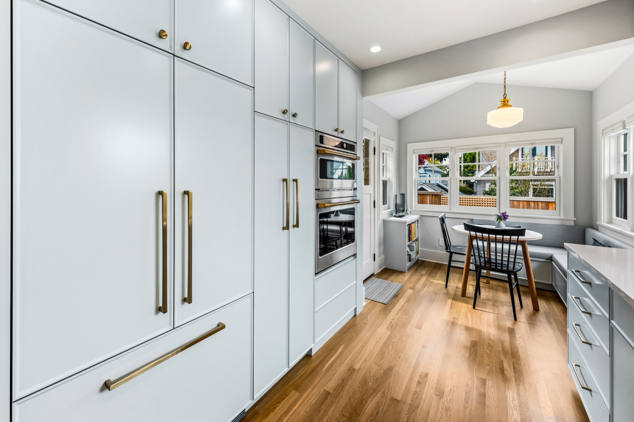 Paneled refrigerator and light blue cabinetry beside the breakfast nook