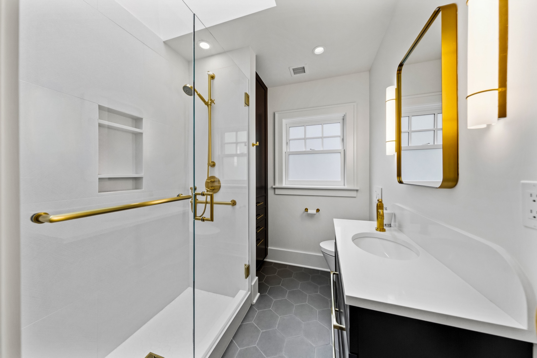 Second bathroom with glass shower and brass fixtures