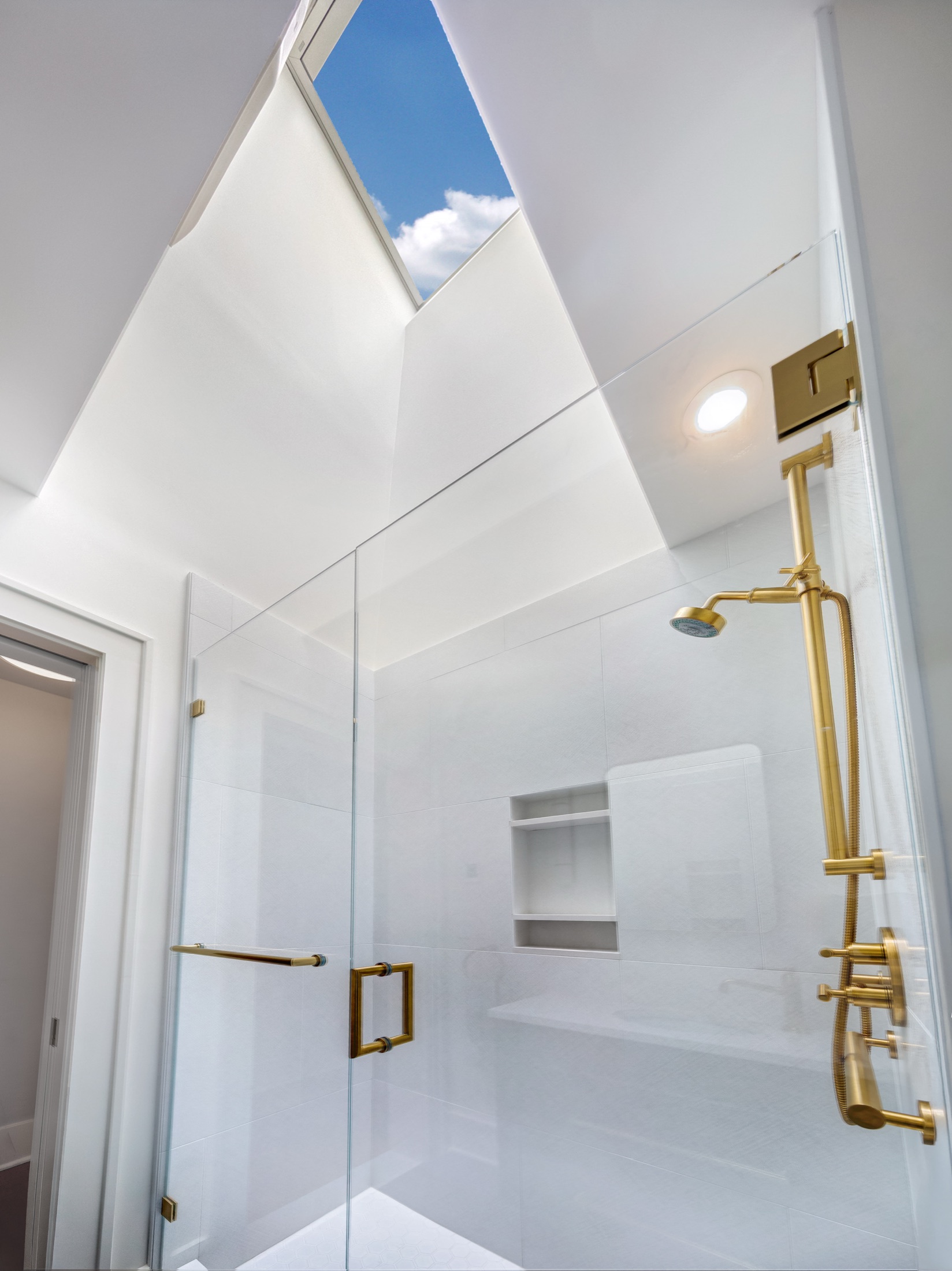 Brass shower fittings and white tiled walls
