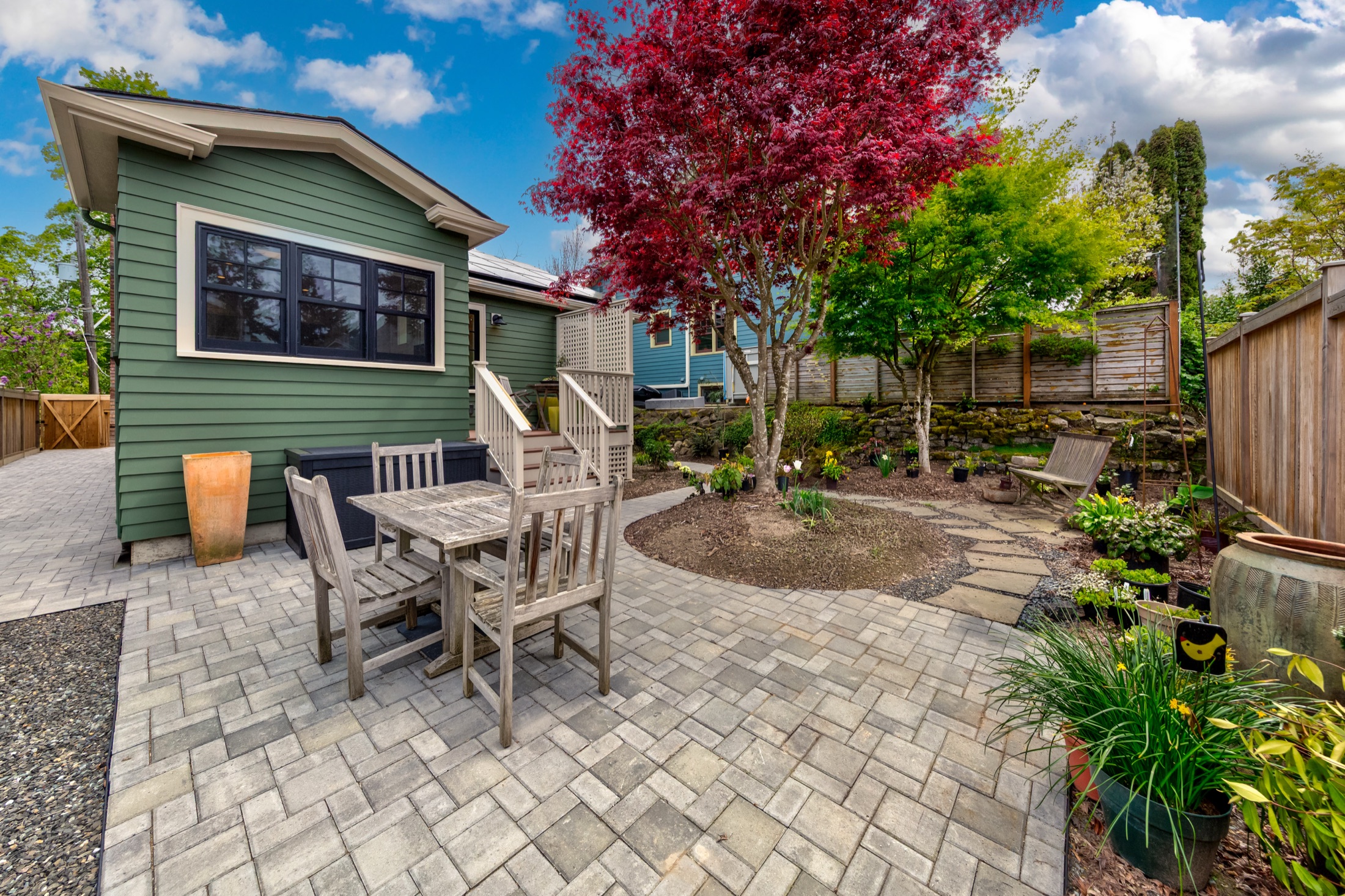 Landscaped backyard patio beside the green home addition
