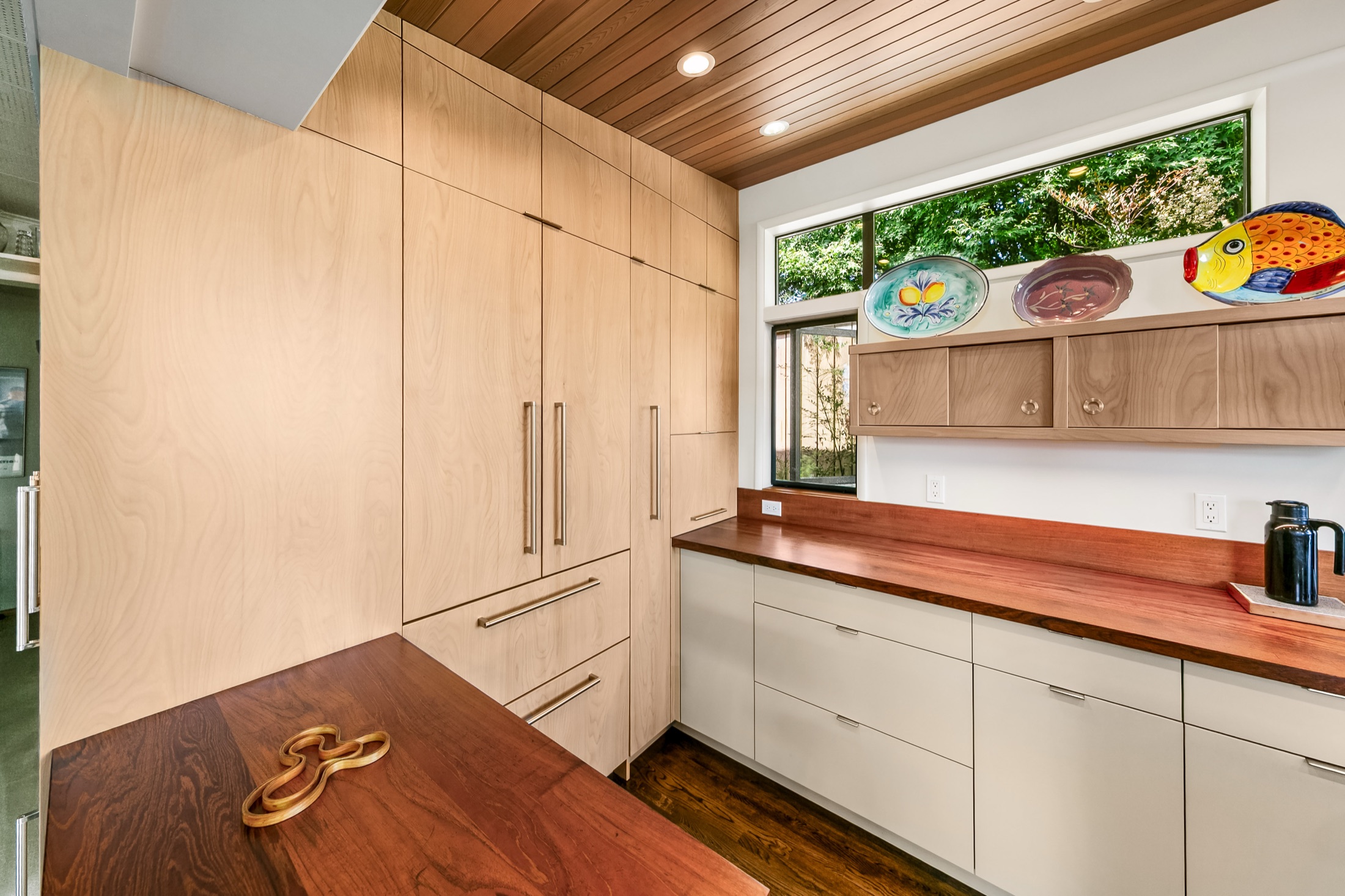 Floor-to-ceiling pantry cabinetry beside the kitchen peninsula