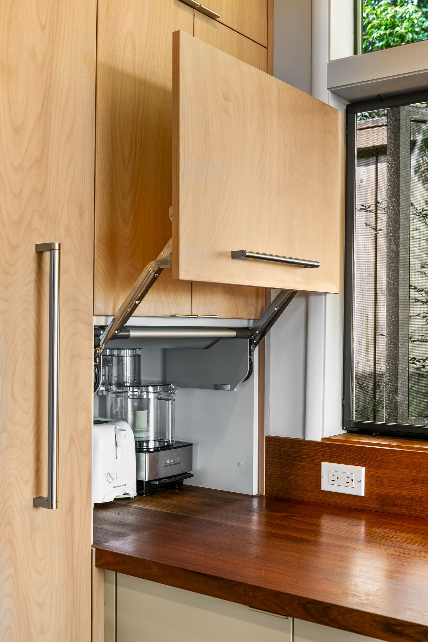 Custom appliance cabinet opened above the wood countertop