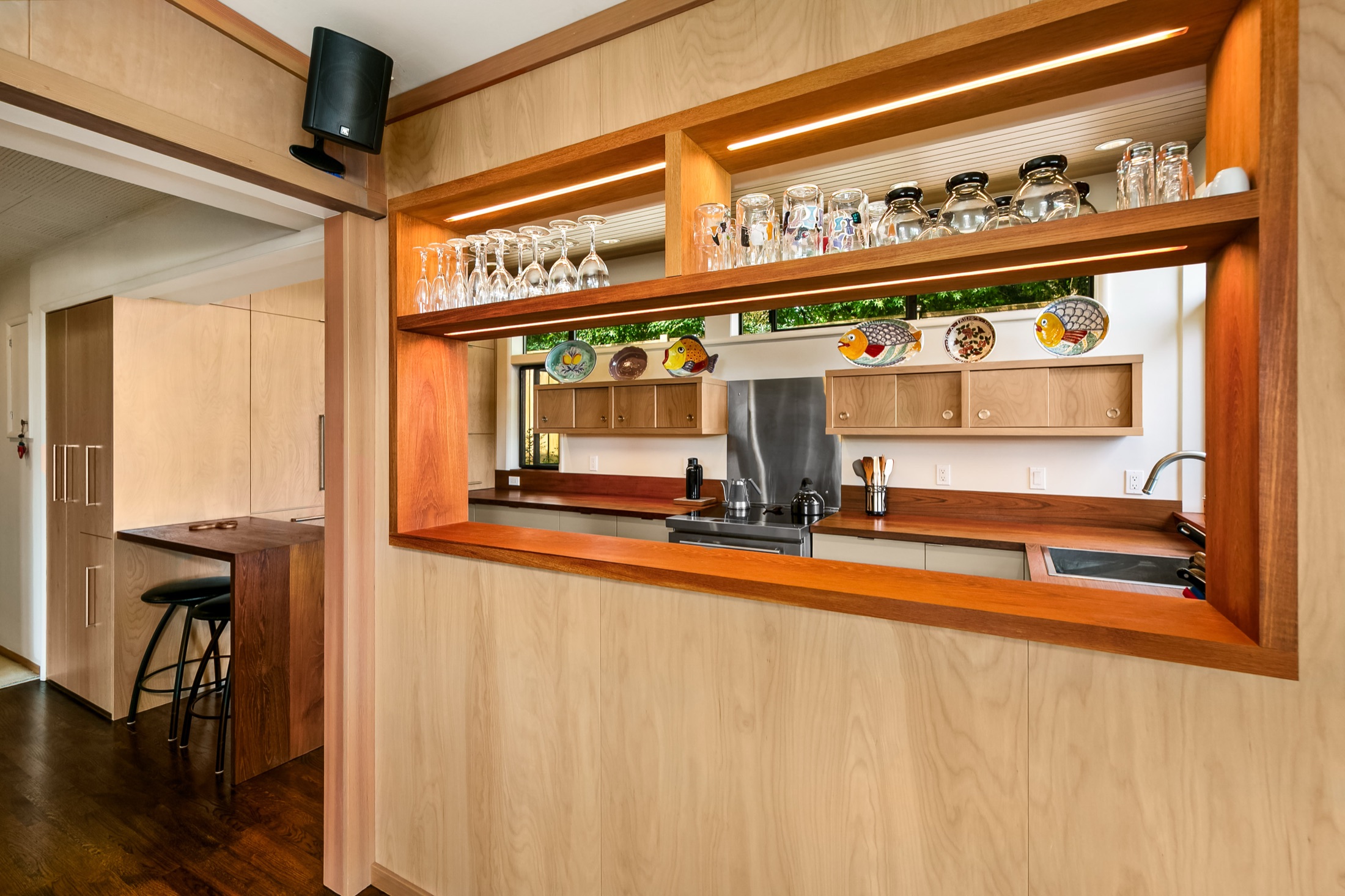 Wood-framed pass-through with open shelving above the kitchen